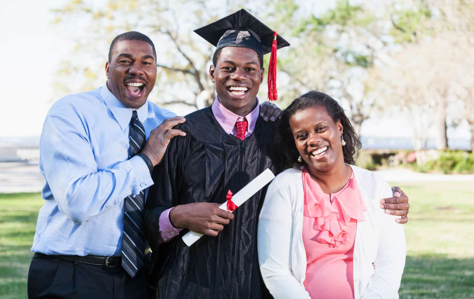 High school student graduating with family