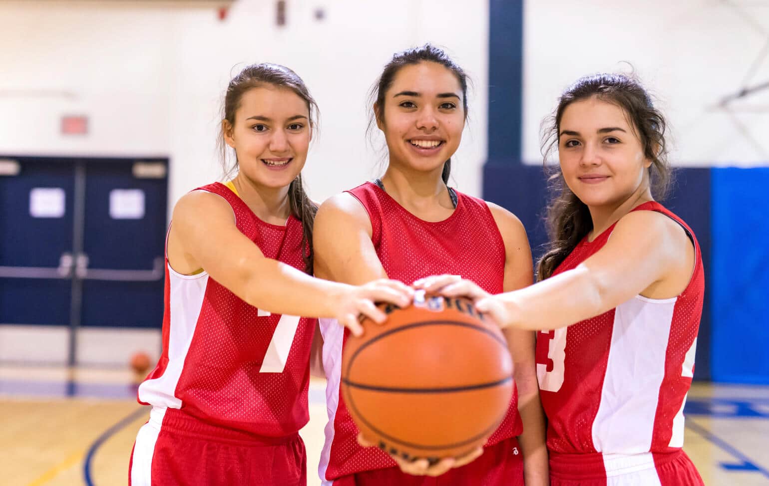 High schoolers holding a basketball