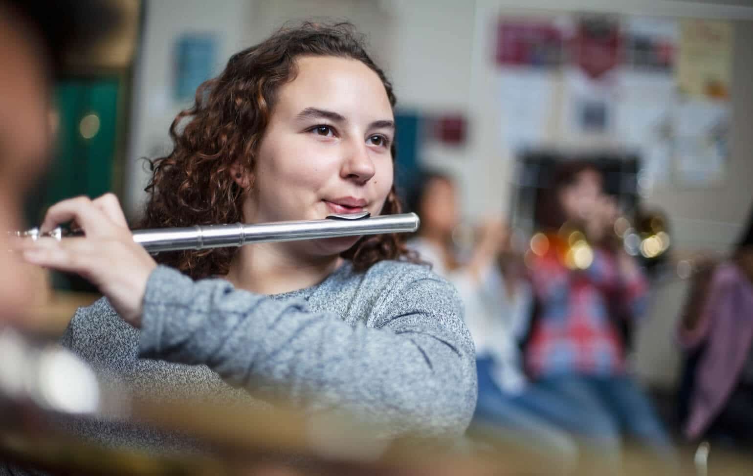 Student playing flute in a community band